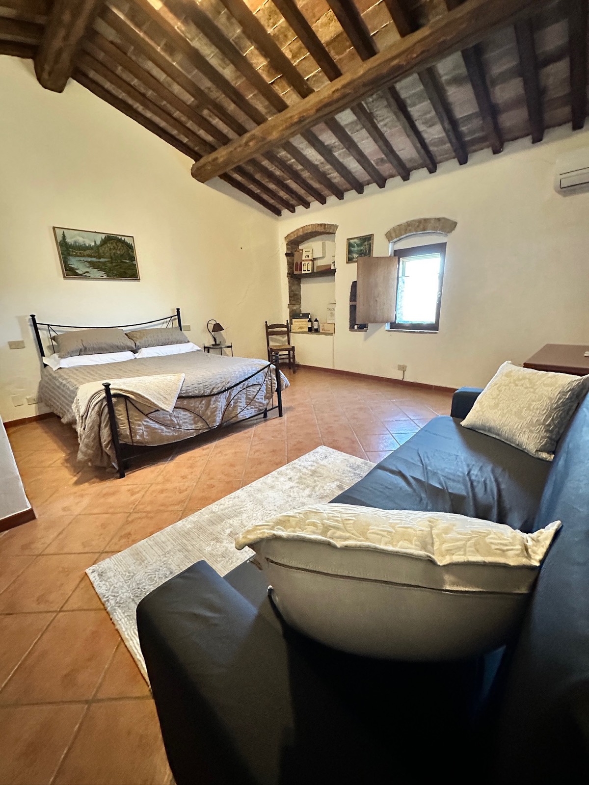 Master Suite del Agriturismo Oria — cama matrimonial, sofá y vigas del siglo XVI