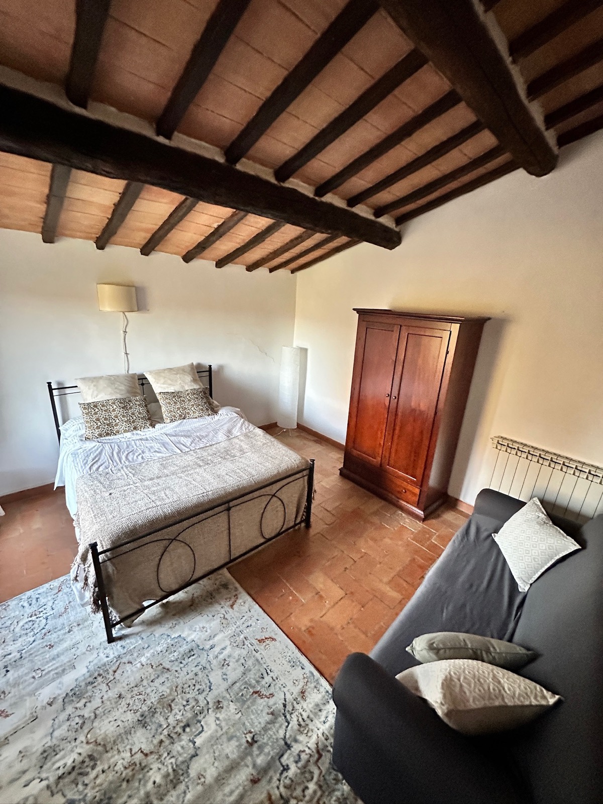 Sala del Capítulo — habitación con cama matrimonial, ropero antiguo y sofá, en el Agriturismo Oria